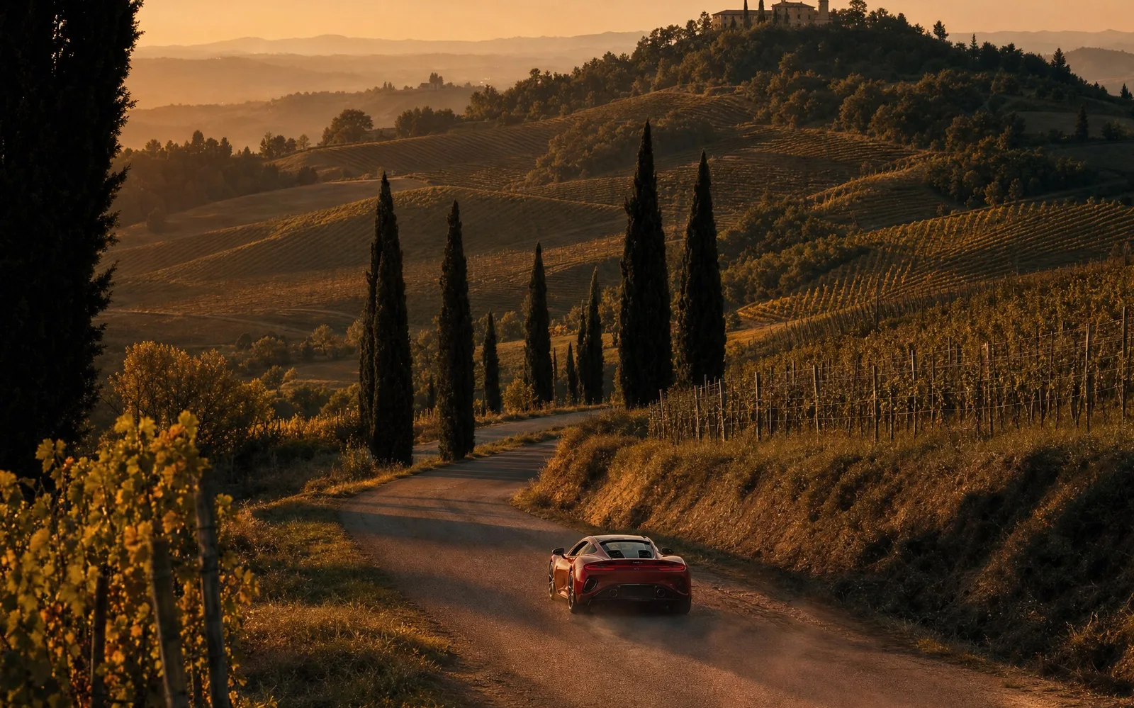A sports car on a winding road through the hills of Emilia-Romagna at golden hour
