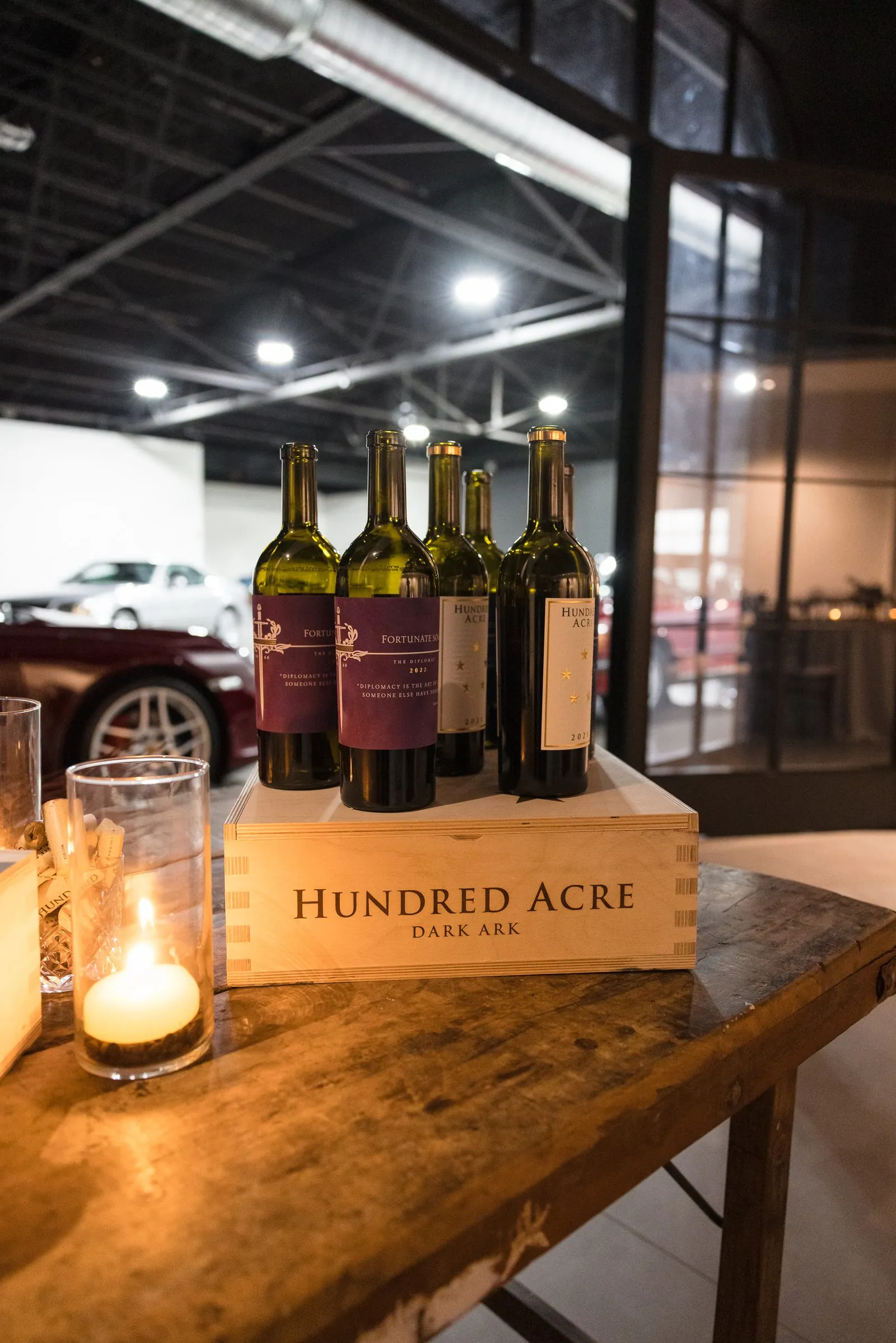 Hundred Acre wine bottles staged beside the collection at an Archive partner event