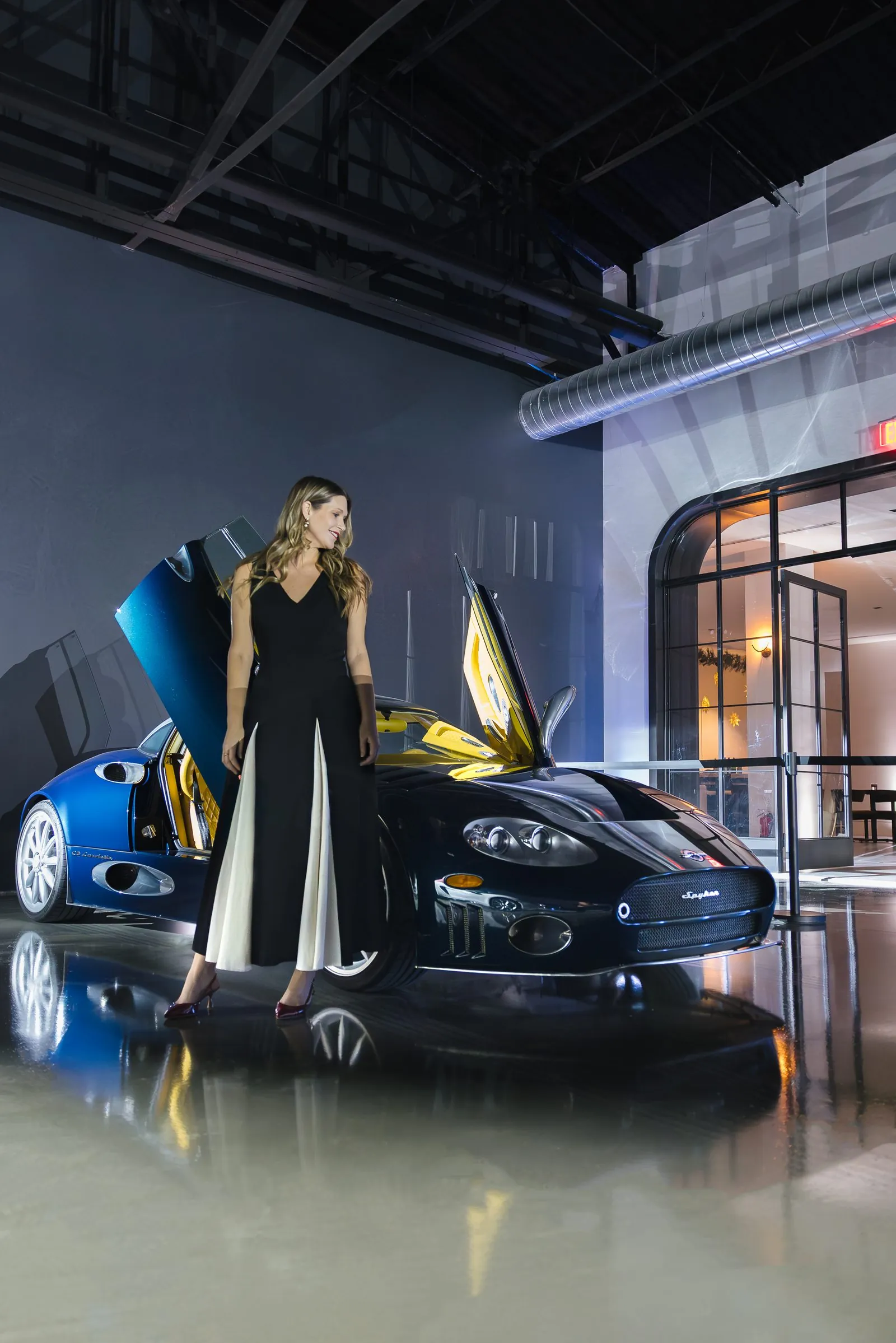 A member in evening wear beside a collector Spyker in the Archive gallery